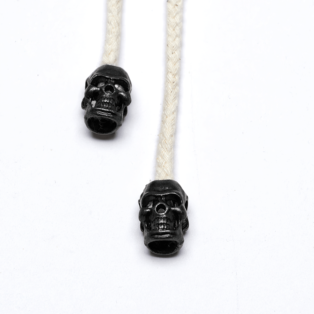 Close-up of skull-shaped beads on a white braided cord, perfect for punk or gothic accessories.