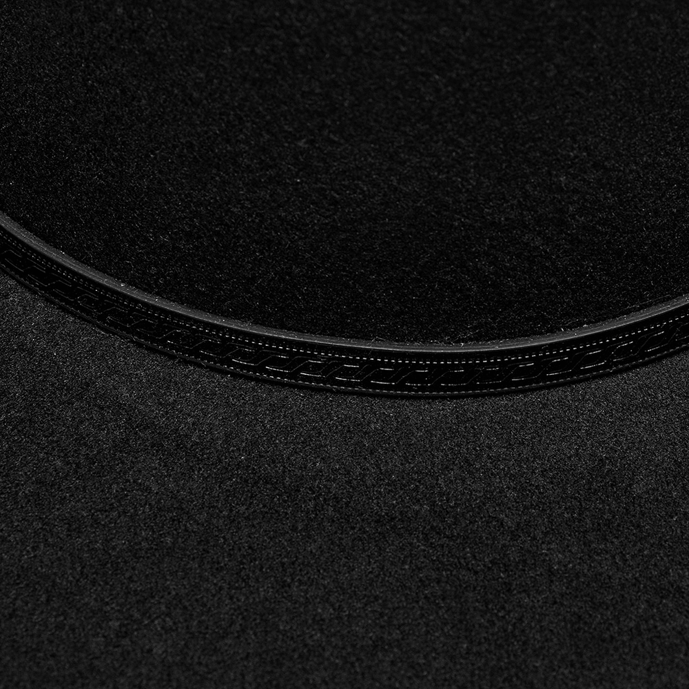 Close-up of the elegant black suede fabric and textured embossed loop on a gothic wide brim hat.