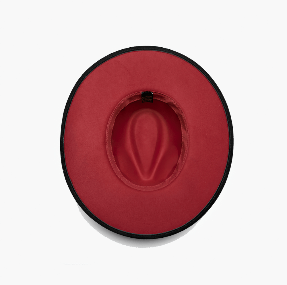 Top view of an elegant wide brim suede gothic hat in vibrant peach with a black edge and spacious interior.