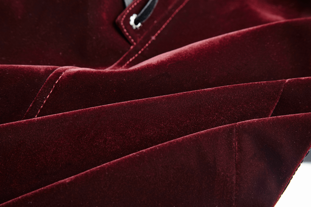 Close-up of wine red velvet fabric showcasing luxurious texture of Gothic jacket.