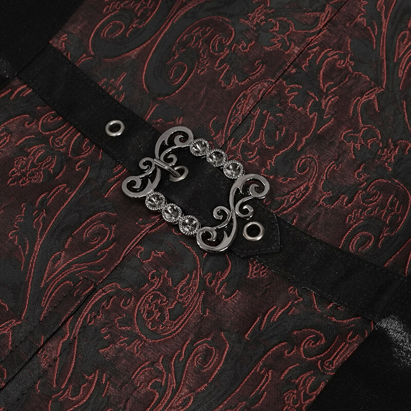 Close-up of wine-red gothic waistcoat with ornate silver buckle and intricate black floral pattern.