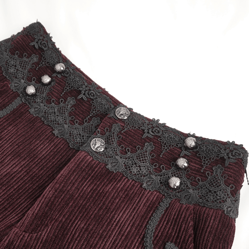 Close-up of wine-red corduroy trousers featuring intricate black lace trim and decorative buttons.