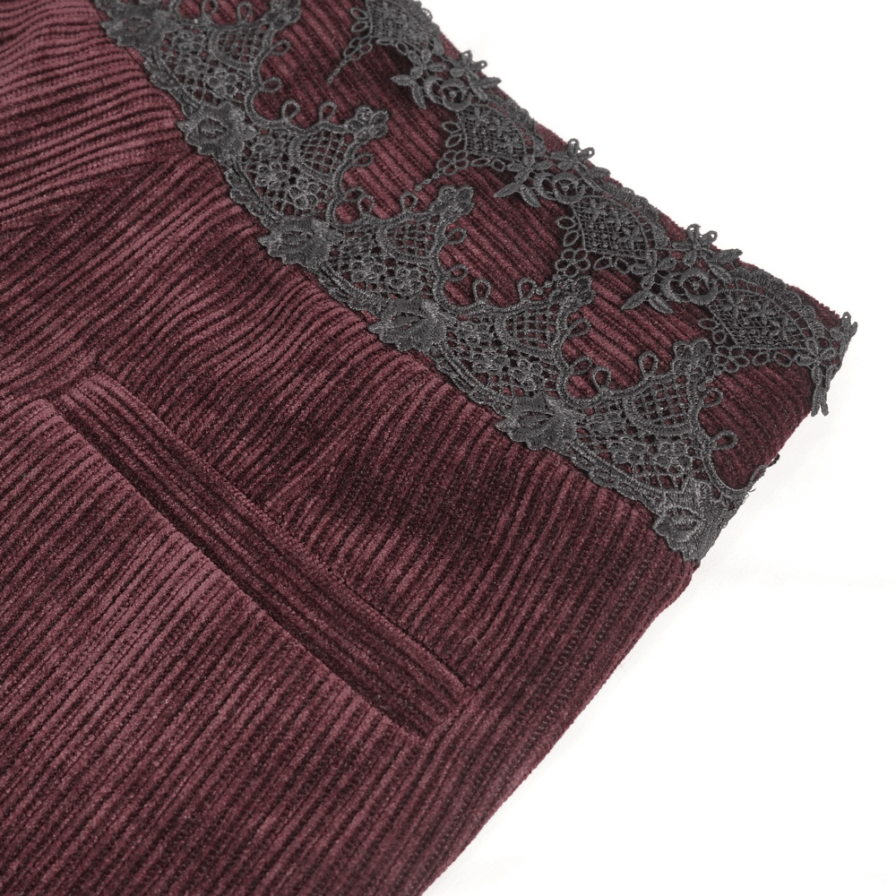 Close-up of wine red corduroy trousers featuring intricate black lace trim.