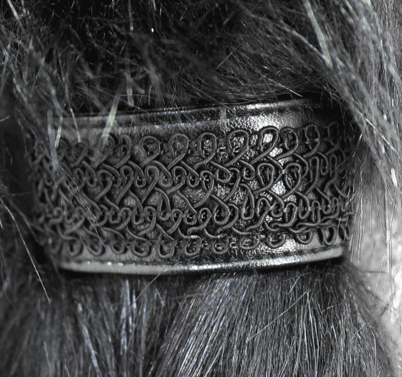 Close-up of a decorative black hair band with intricate vintage patterns.