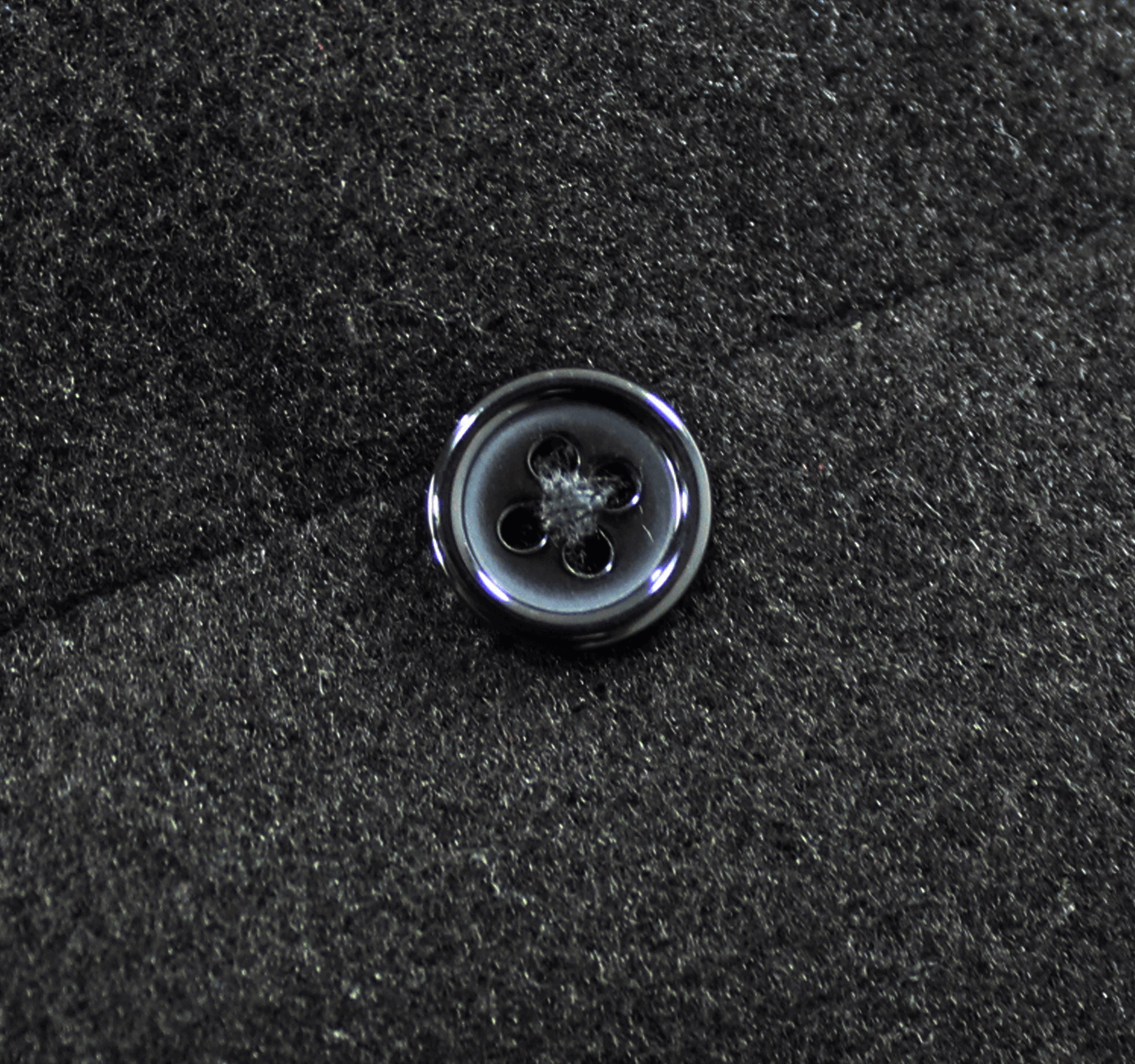 Close-up of a vintage black coat button showcasing gothic style and intricate detailing.