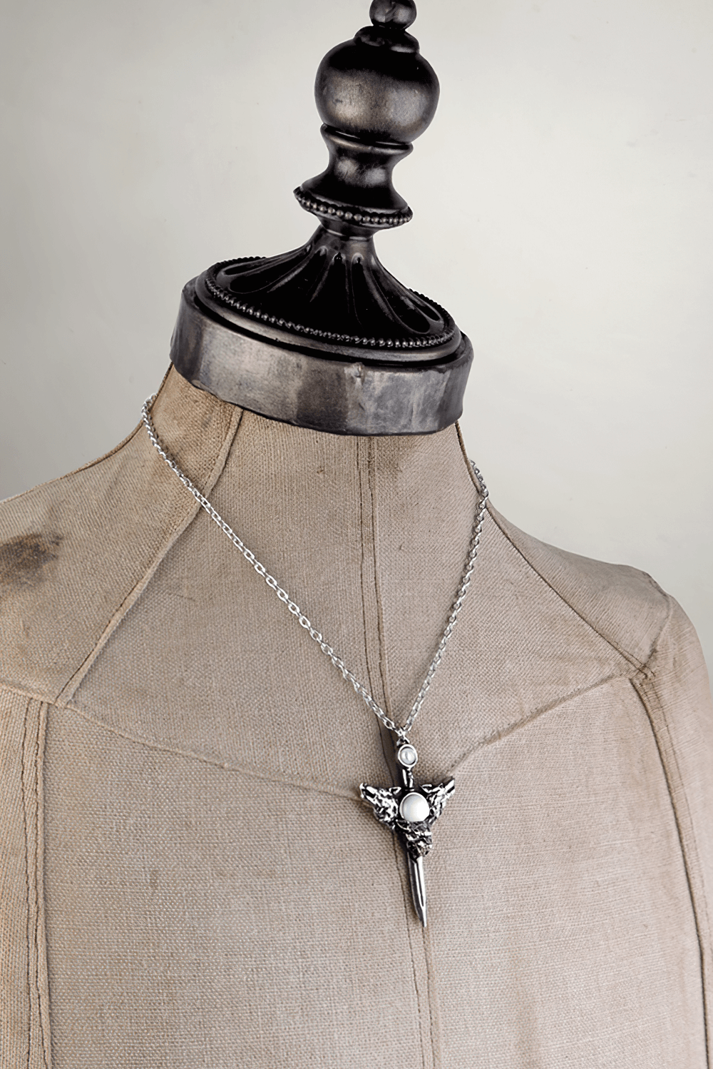 Wolverine Moon Pendant with silver dagger and moonstones displayed on a dress form, showcasing its mystical design.