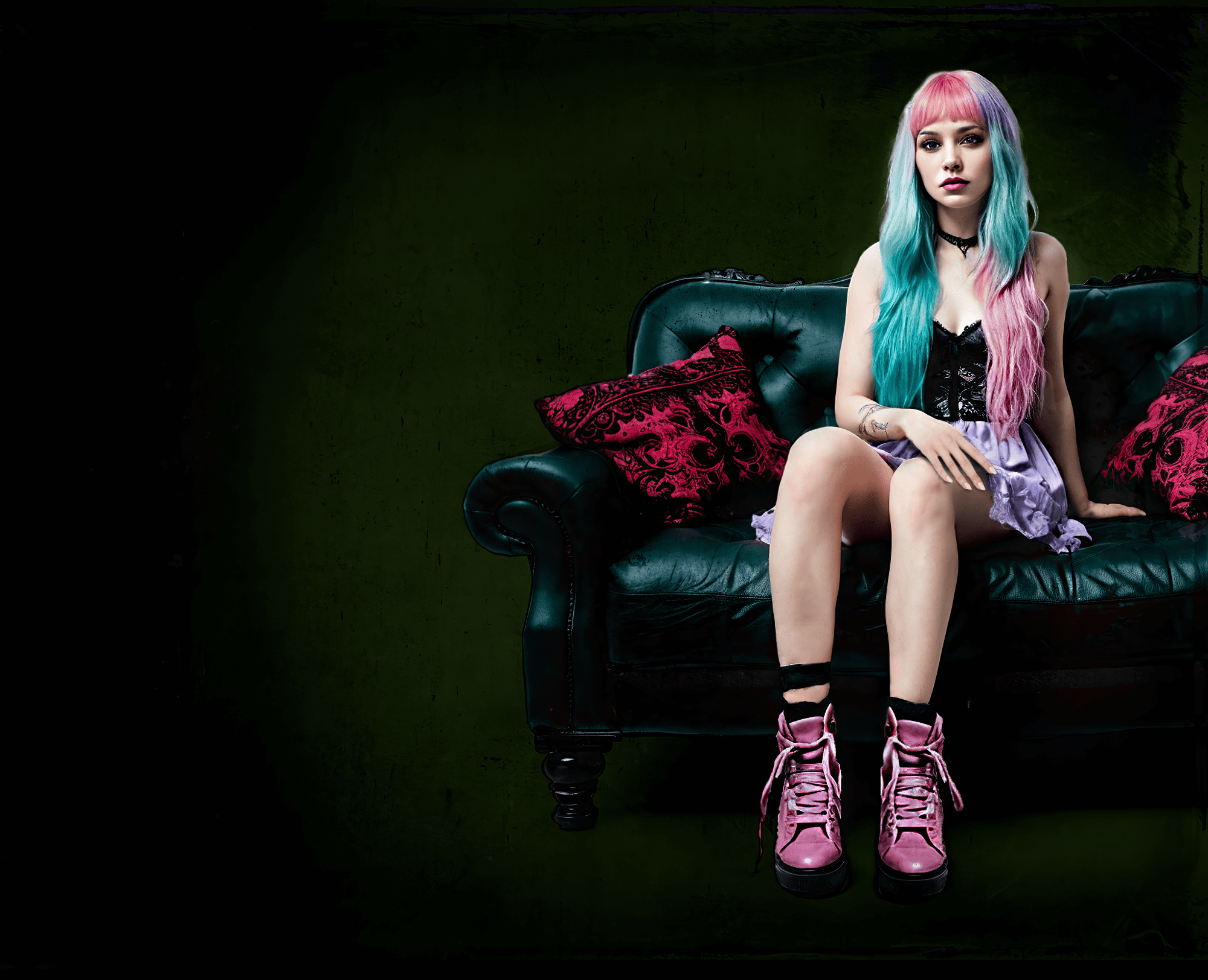 Woman with pink hair sits on couch in a gothic setting