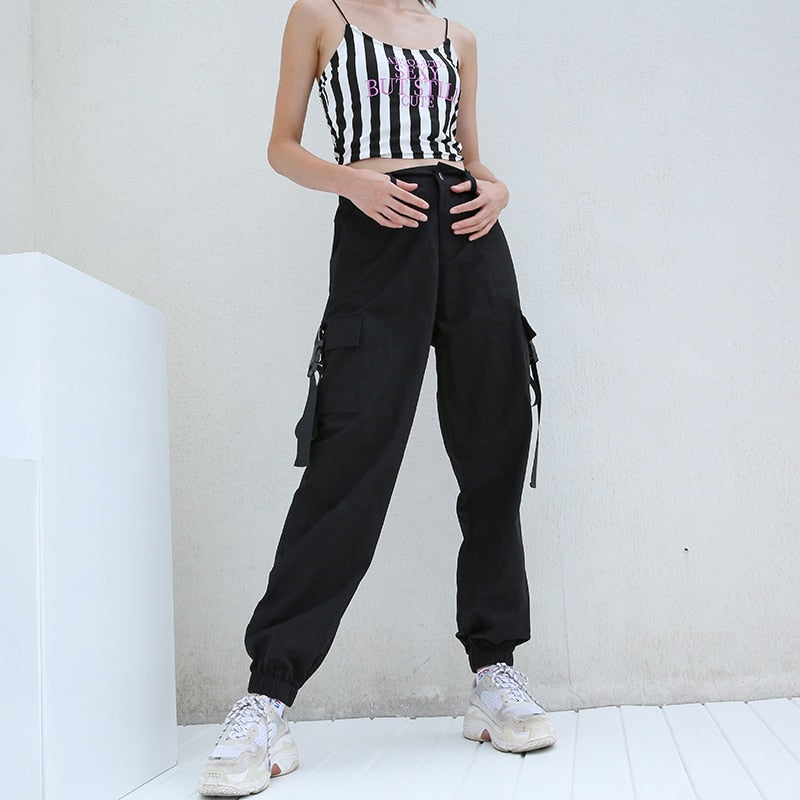 Trendy women's black high-waisted cargo joggers with suspenders, styled in a rock fashion for concert-ready outfits.
