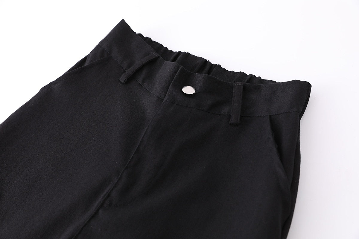 Close-up view of high waist black cargo joggers with elastic waistband and button detail, perfect for a rock style outfit.