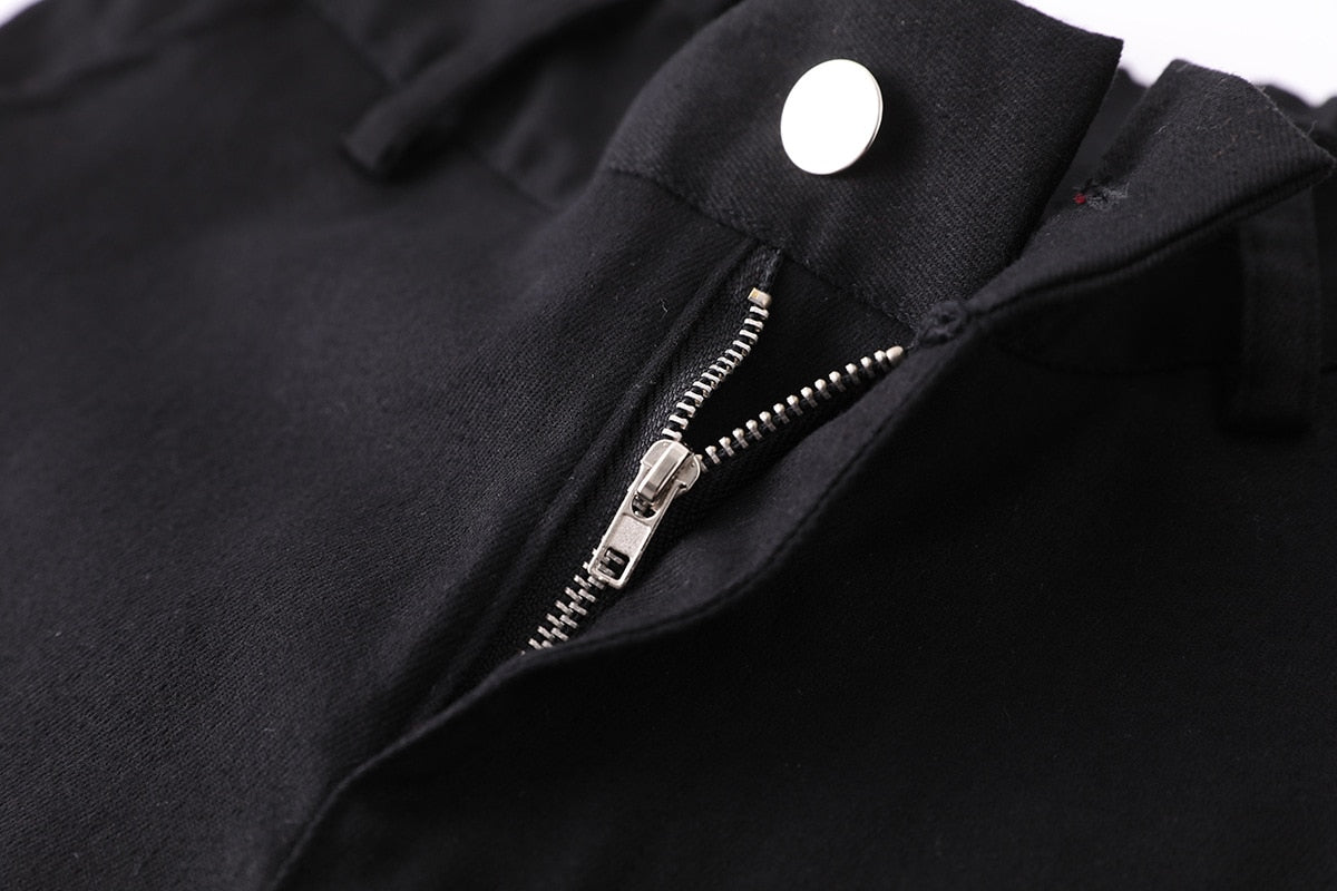 Close-up of zipper and button detail on black high-waist cargo joggers for women in rock style.