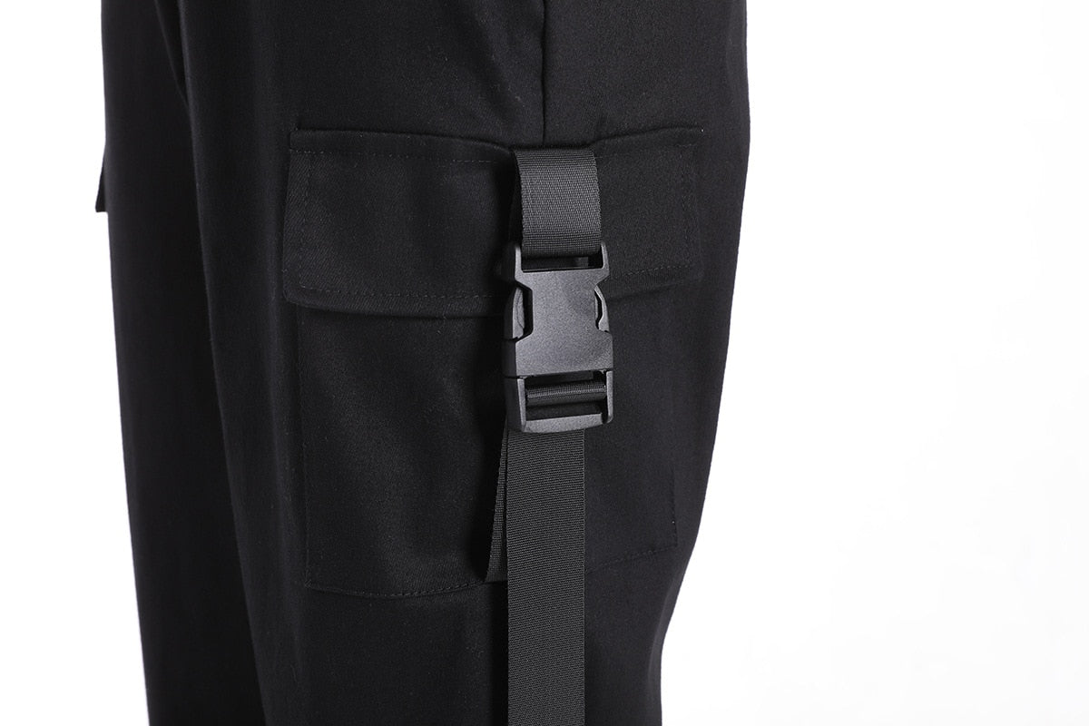 Detail of black high-waist cargo joggers featuring suspenders and side pockets, perfect for rock style outfits.