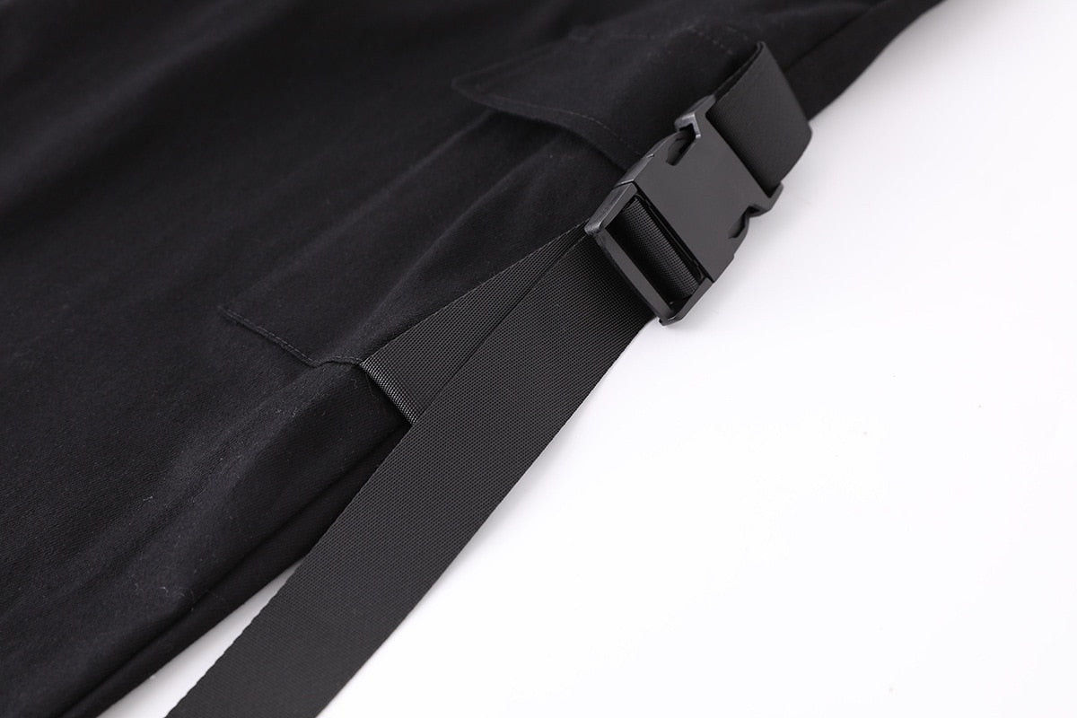 Close-up of black suspenders and buckle detail on women's high-waisted cargo joggers.