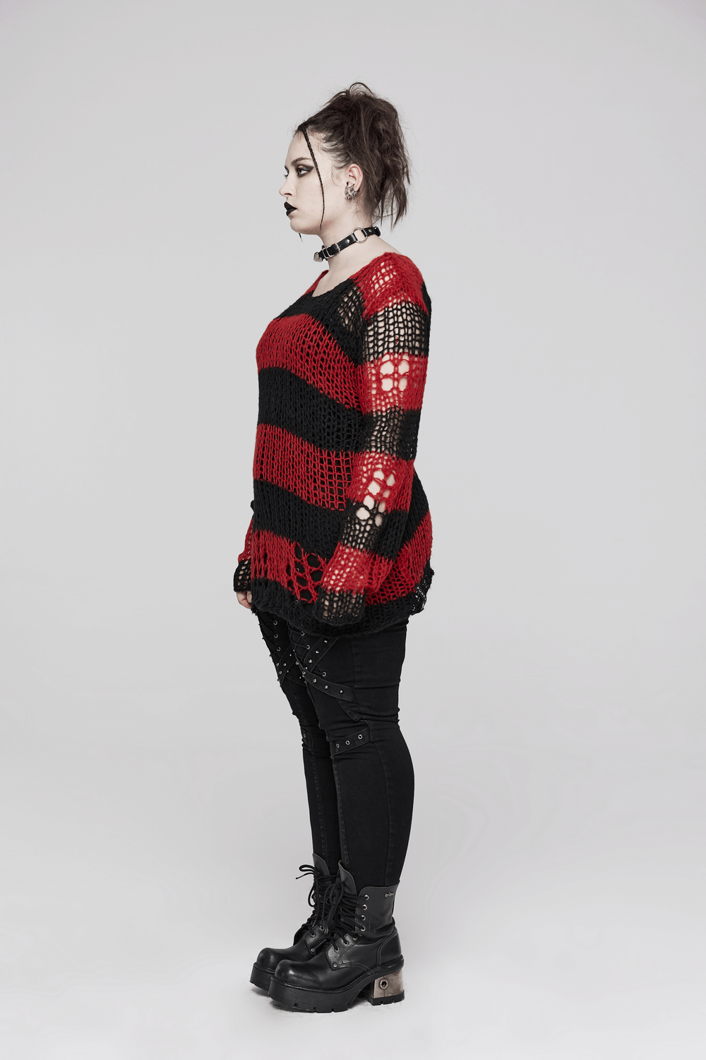 Side view of a woman in a red and black striped mohair pullover sweater, showcasing an edgy Gothic style.