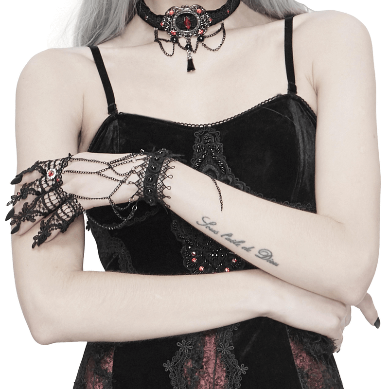Gothic Victorian black lace gloves with chains and red accents, worn by a model in a stylish black outfit.