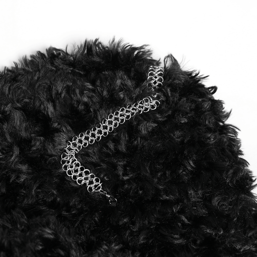 Close-up of a black faux fur fabric with silver chain details, perfect for a gothic hooded cape.