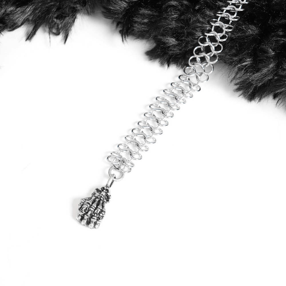 Close-up of gothic chain detail with claw pendant on a black faux fur hooded cape.