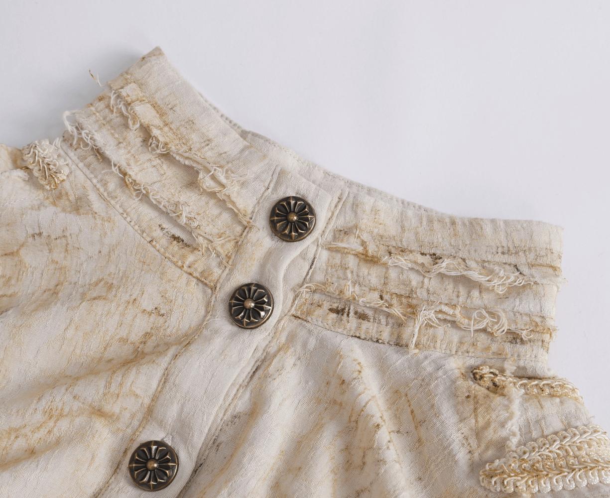 Close-up of antique ruffle sleeves shirt showing vintage buttons and intricate detailing on the collar and cuffs.