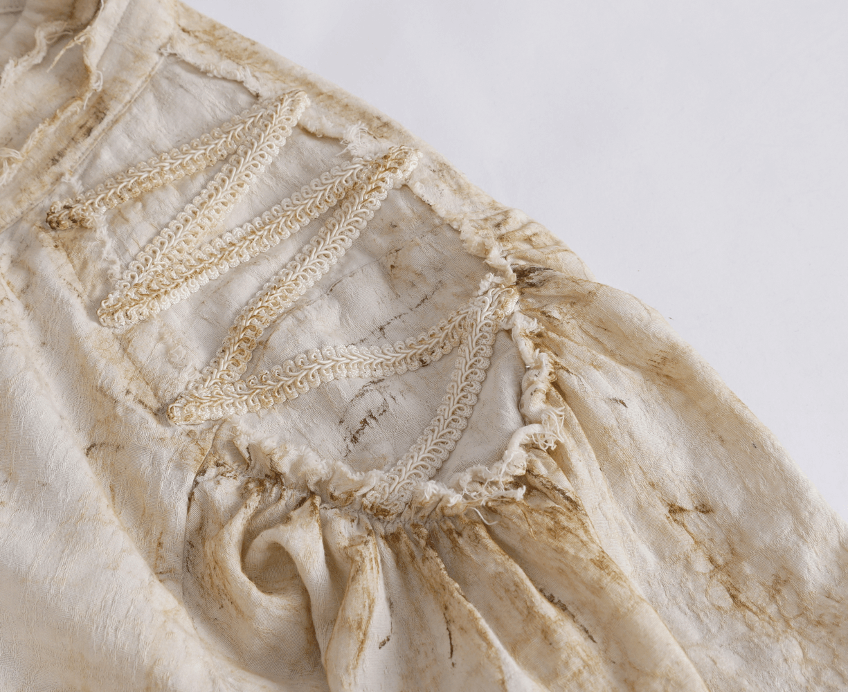 Close-up of antique ruffle sleeve detailing on a vintage women's shirt with elegant high collar.