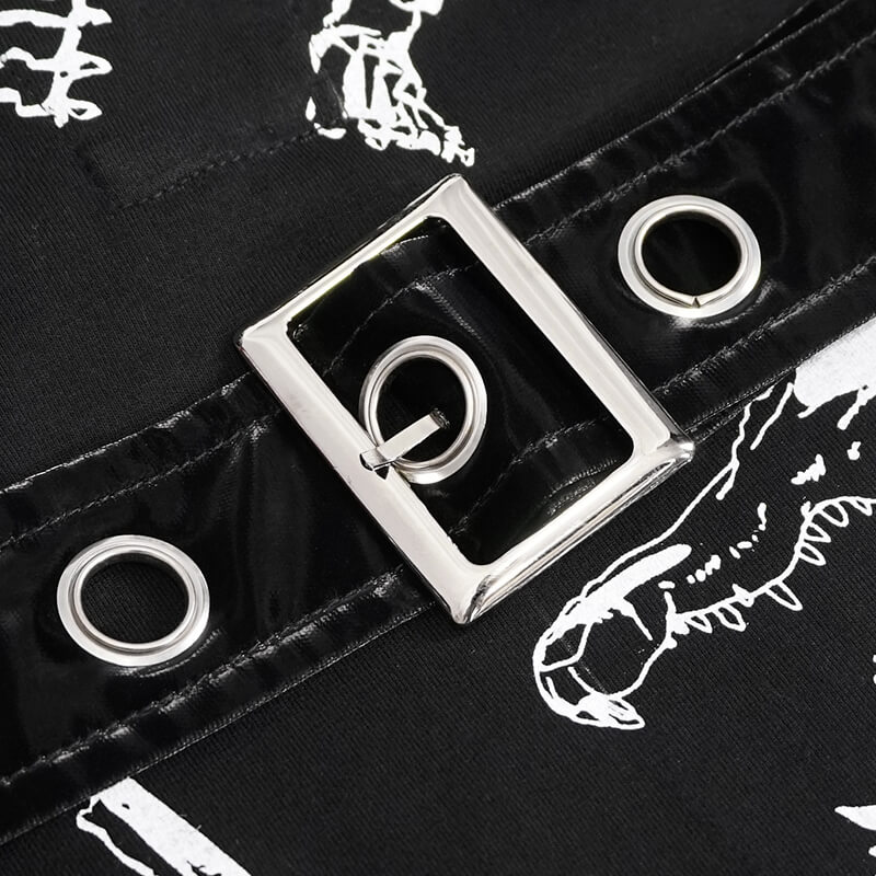 Close-up of silver buckle detail on black gothic dress with mesh sleeves, showcasing stylish design elements.