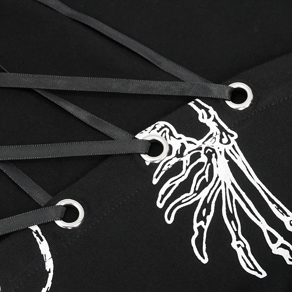 Close-up of black dress detailing featuring lace-up ribbons and a striking graphic design, showcasing gothic elegance.