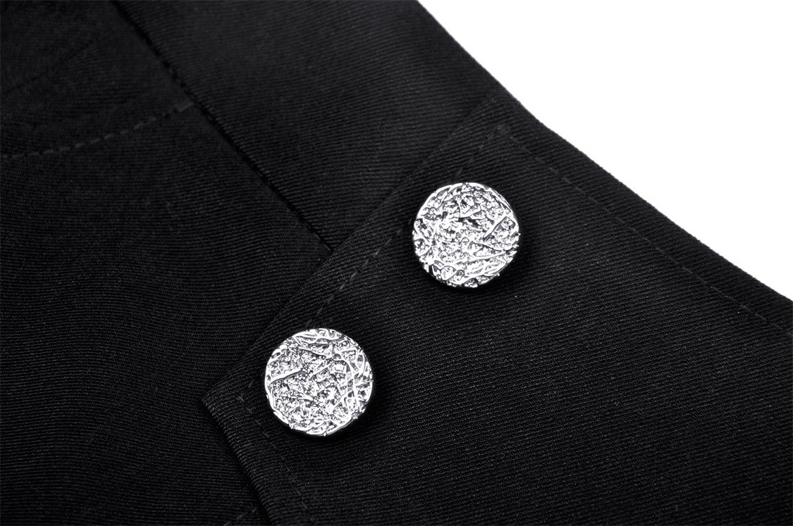 Close-up of shiny silver buttons on a black asymmetrical mini skirt, highlighting punk rock style.