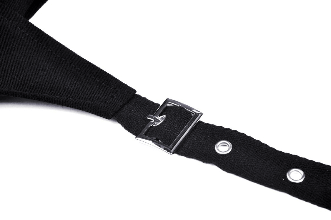 Close-up of black strap and buckle detail from an asymmetrical mini skirt, perfect for punk rock style.