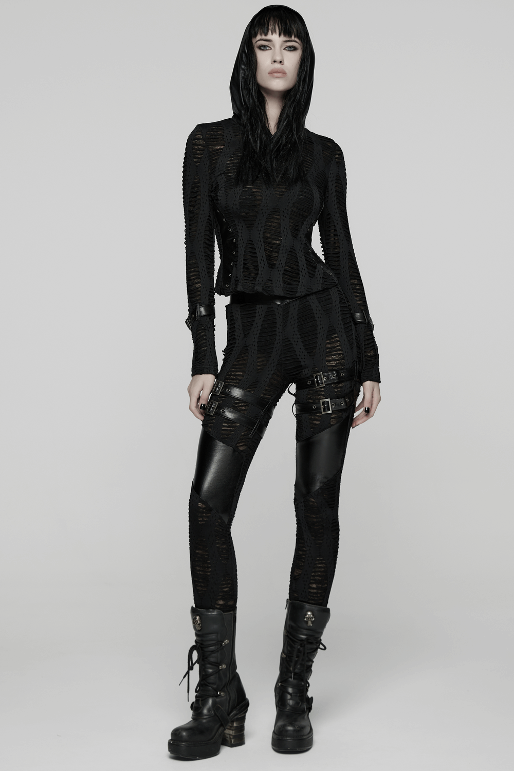 Women's Black Buckled Leggings with Textured Design worn with a stylish black top and edgy boots.