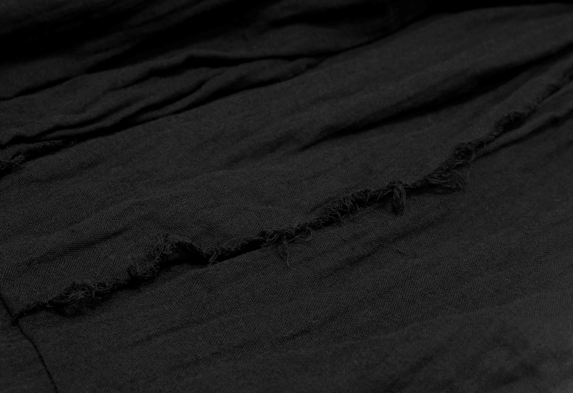 Close-up of black fabric featuring unique ripped detailing, perfect for a gothic style dress.