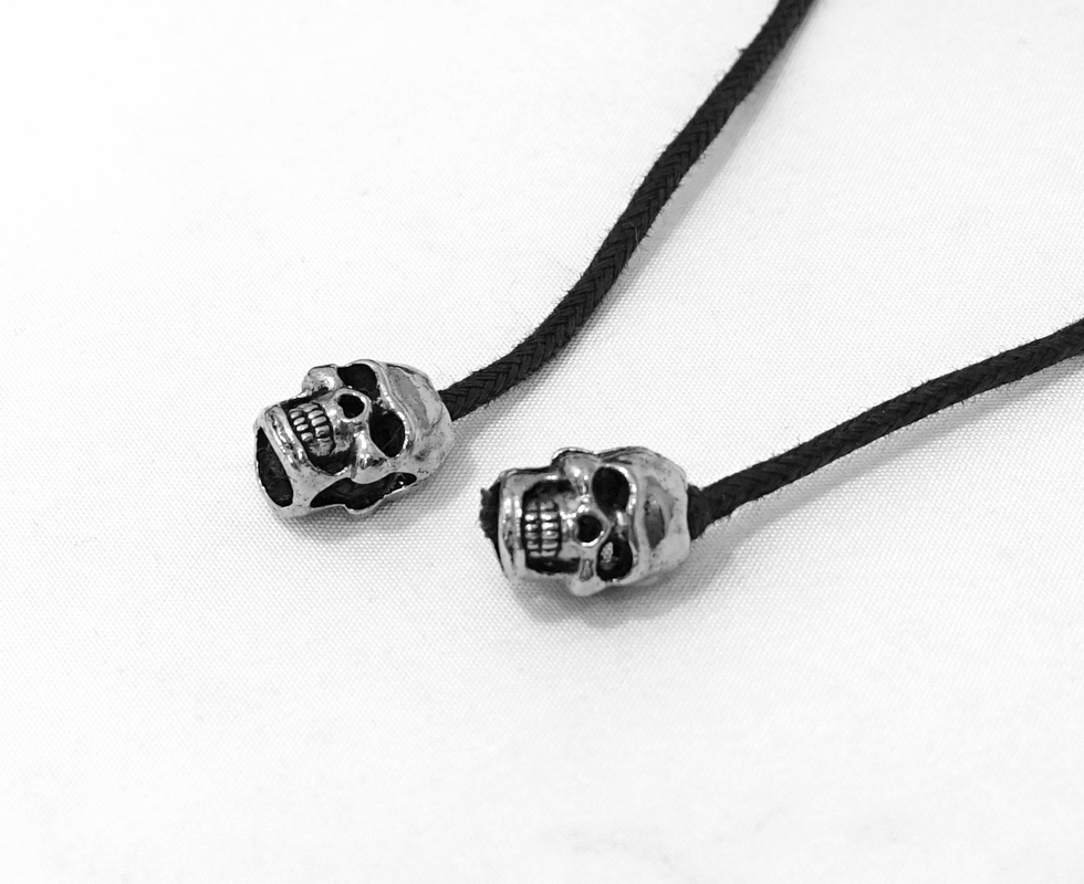 Skull beads on a black cord, perfect for gothic or edgy fashion accessories.
