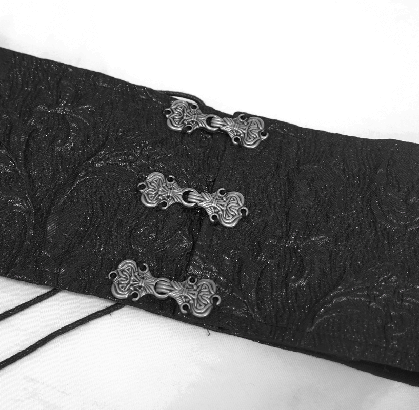 Close-up of ornate silver clasps on a textured black fabric, perfect for gothic style clothing.