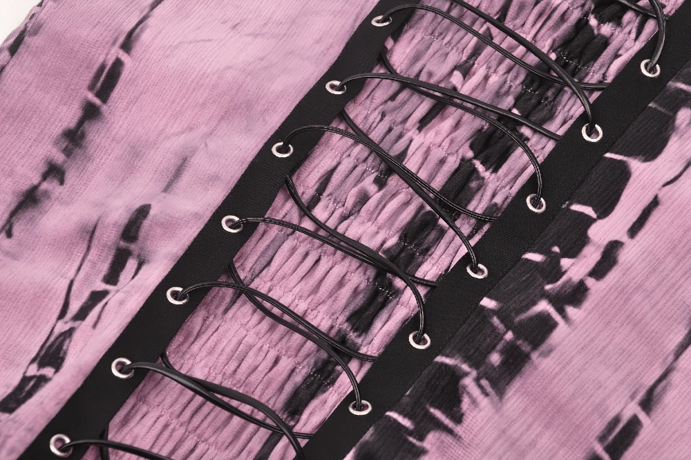 Close-up of pink tie dye pattern on women's black lace corset dress with lacing details.