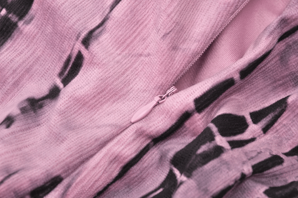 Close-up of pink tie-dye fabric detailing on women's corset dress with zipper.