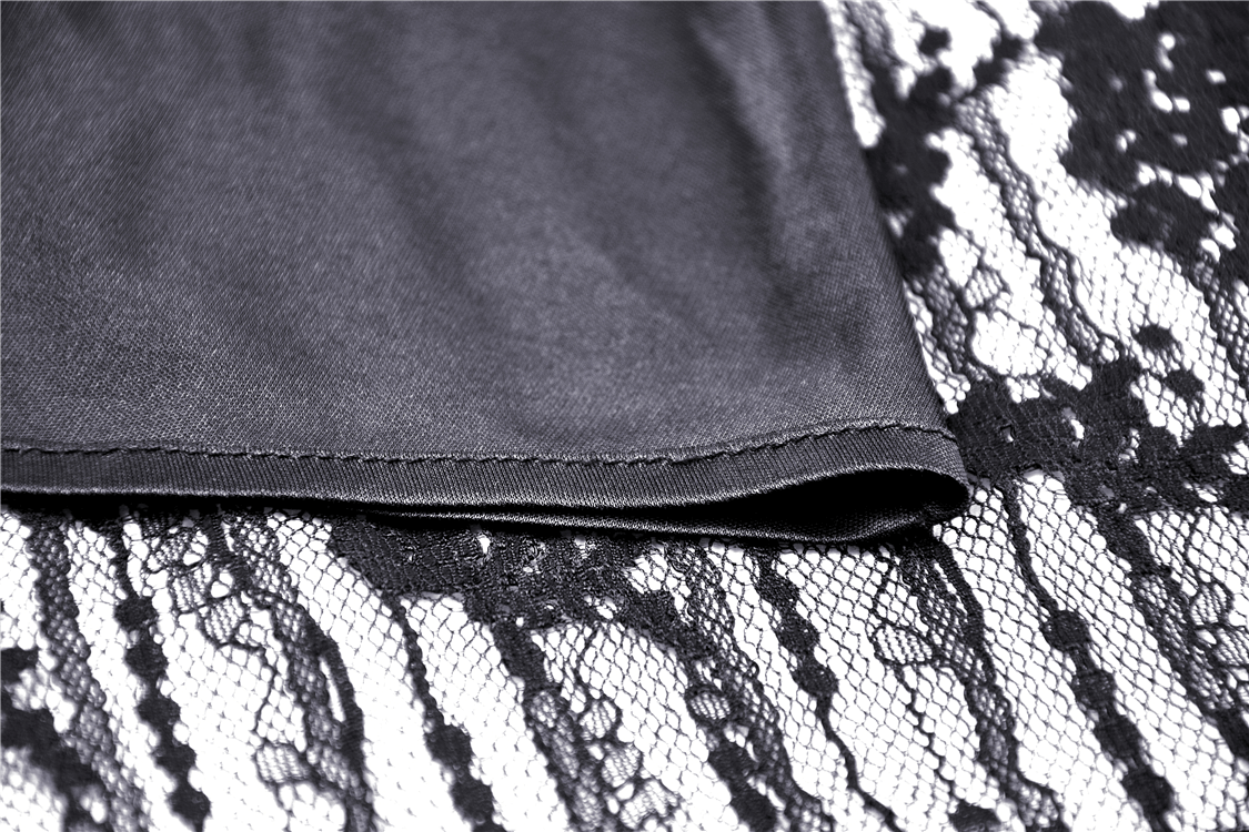 Close-up of black lace detail and fabric of a women's off-shoulder dark witch dress, highlighting elegant textures.
