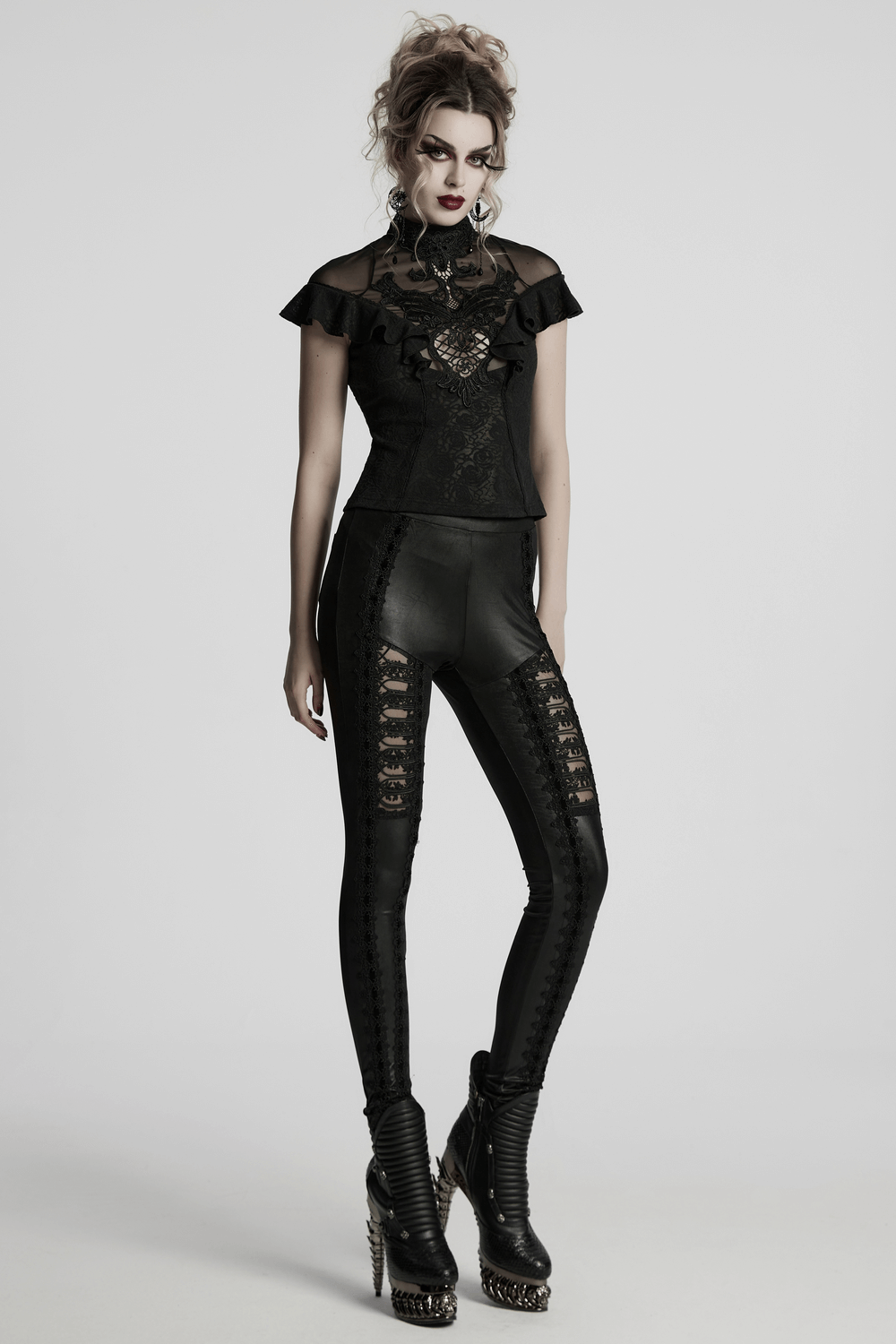 Women's gothic black lace ruffle top with embroidered applique, paired with stylish black leggings and platform boots.