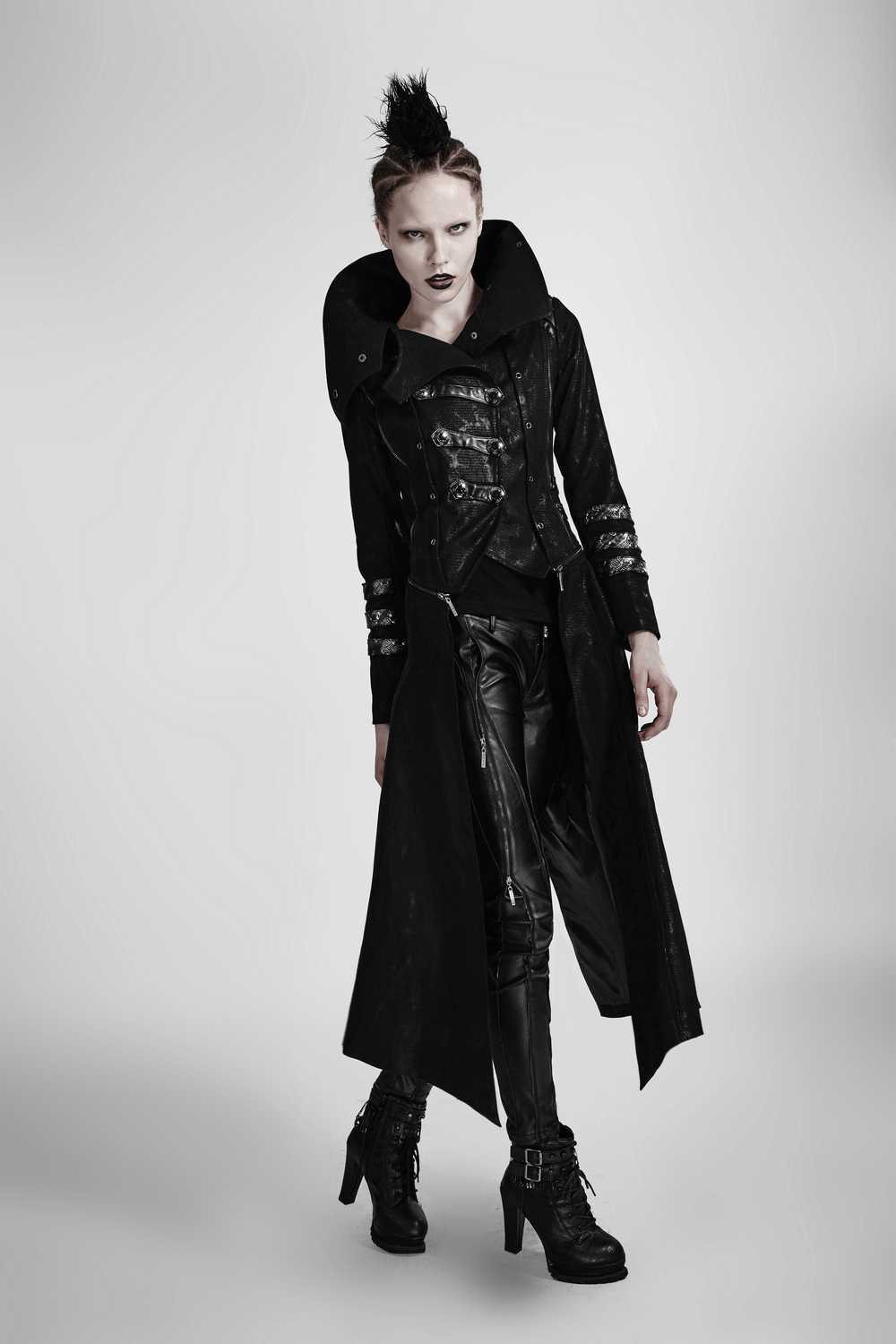 Women's black leather-look long coat with oversized collar and silver trim, embodying gothic fashion.