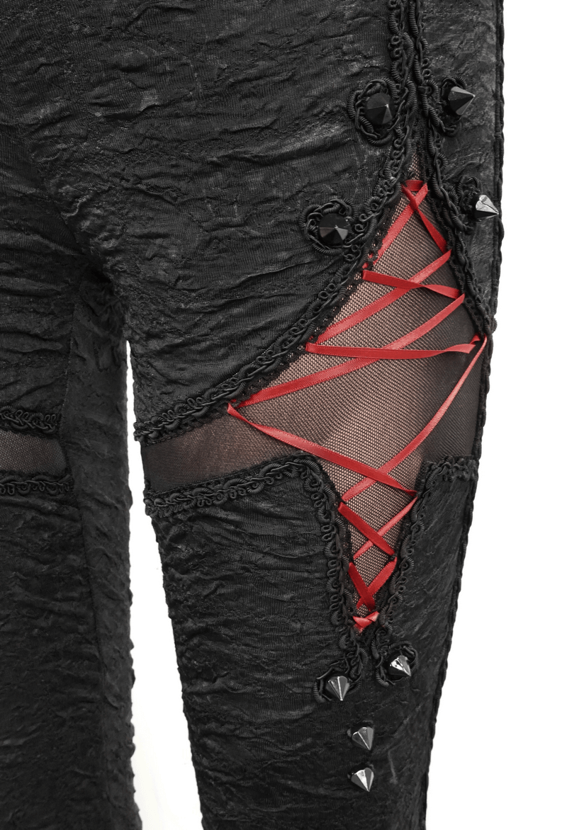 Close-up of women's black gothic leggings featuring red lacing and edgy torn inserts for a stylish look.