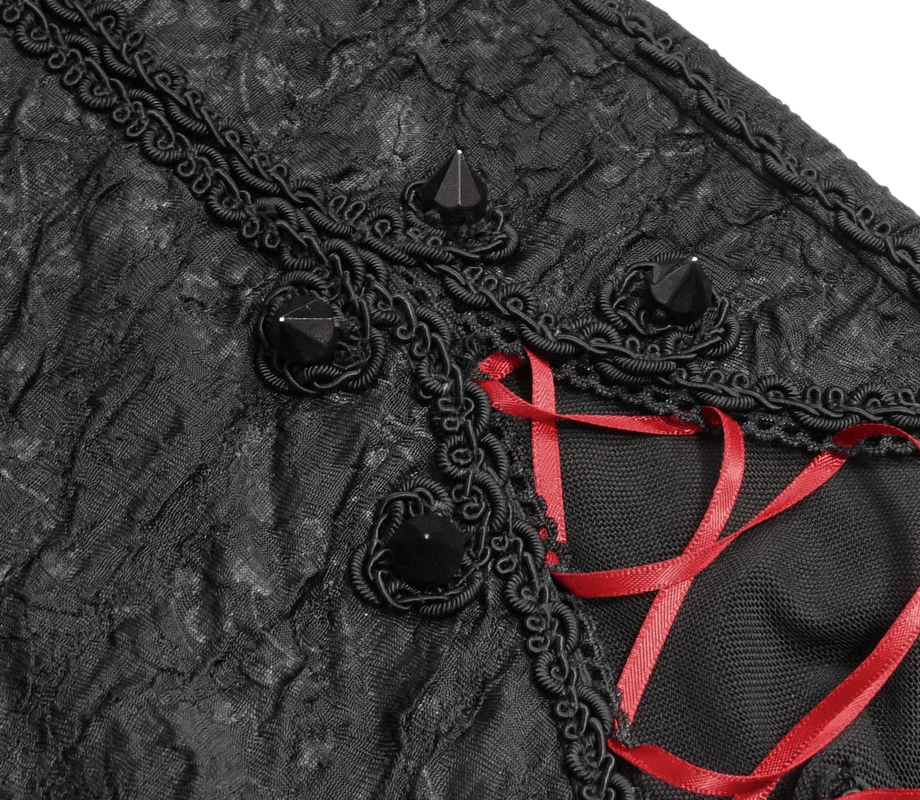 Close-up of gothic black fabric with red lacing and decorative studs, perfect for stylish women's leggings.
