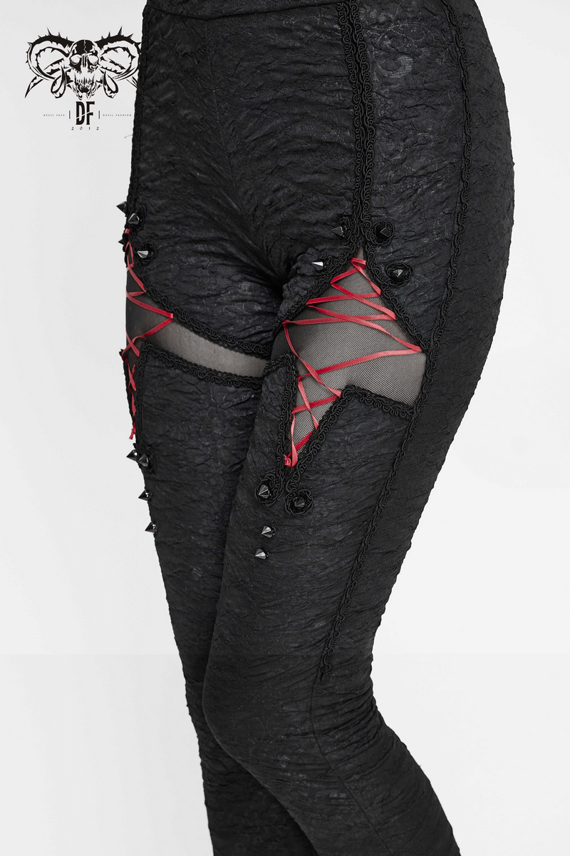 Women's black gothic leggings with red lacing details and torn inserts for a stylishly edgy look.
