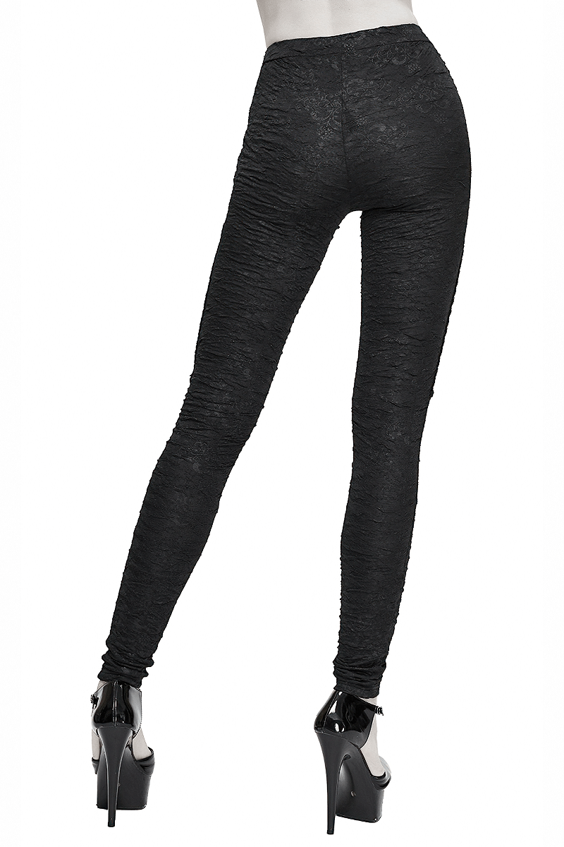 Back view of women's black gothic leggings with ripped design, paired with high heels for a trendy look.