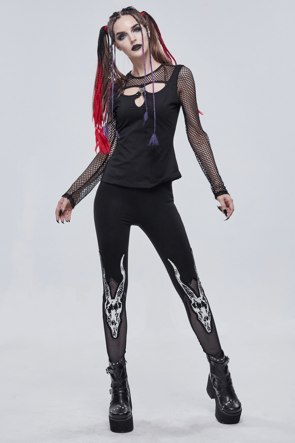 Trendy punk women's outfit featuring black leggings with white goat skull print and a stylish cutout top.