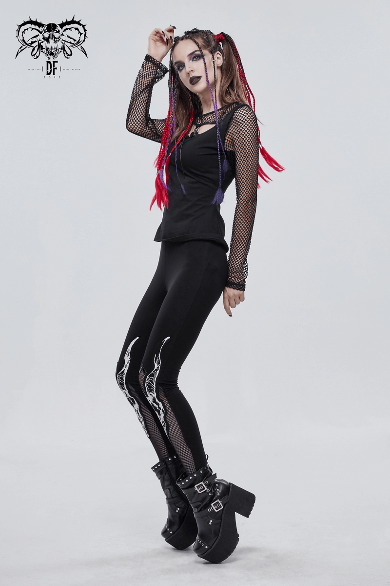 Edgy woman in black leggings with white Baphomet print, styled in punk fashion with vibrant hair and mesh sleeves.