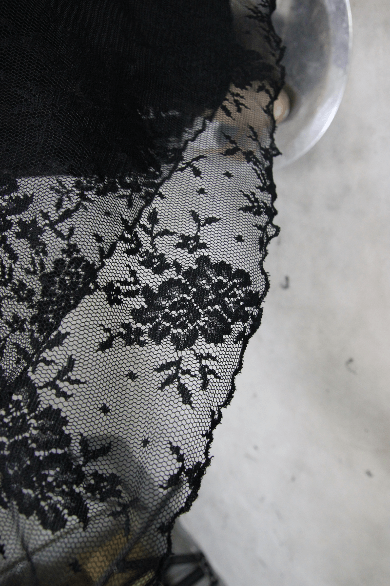 Close-up of intricate black lace fabric with floral patterns, perfect for Gothic style clothing.