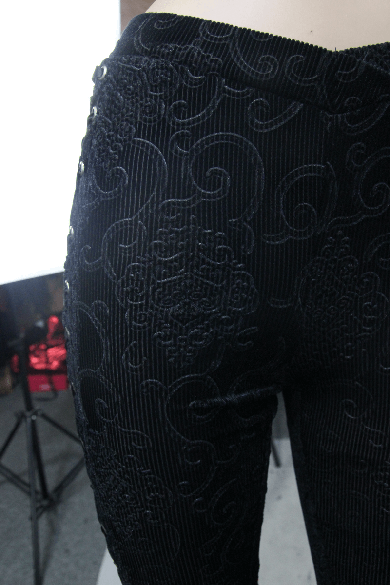 Close-up of women's black lace flare pants featuring intricate patterns and flared cut, perfect for gothic style clothing.
