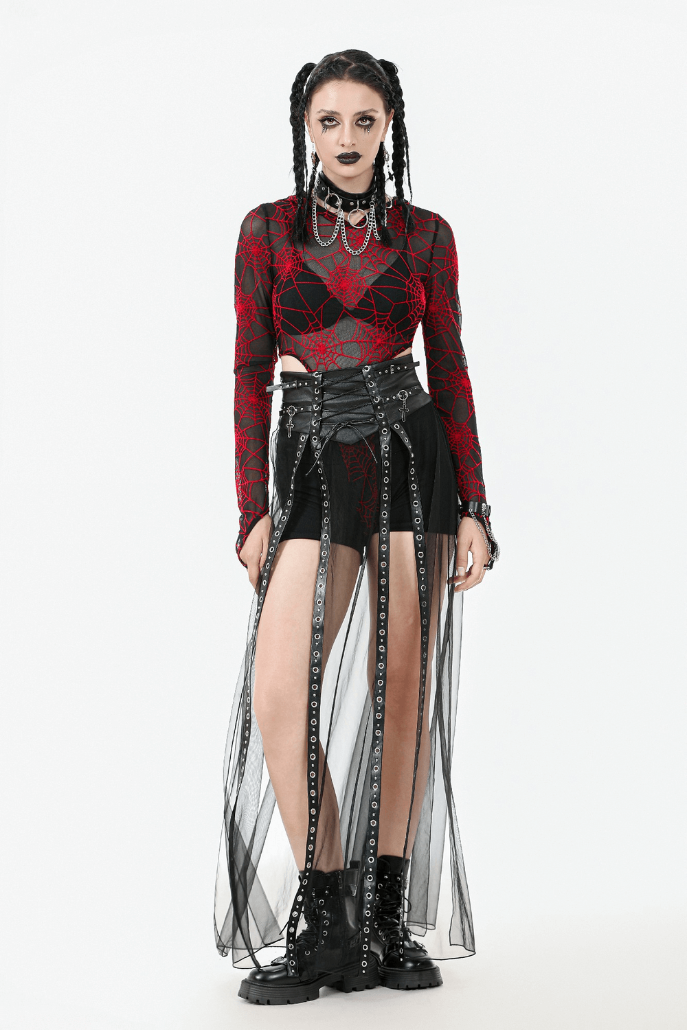 Gothic fashion model wearing a sheer black maxi skirt with chains and a bold red spiderweb top, exuding edgy style.