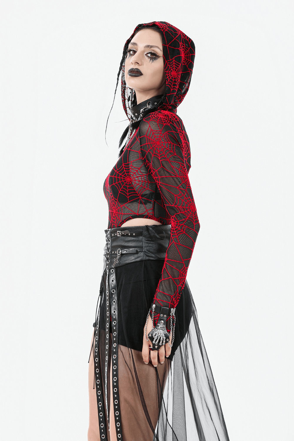 Gothic woman in a red spiderweb bodysuit with a sheer maxi skirt and lace-up waist, showcasing alternative fashion elegance.