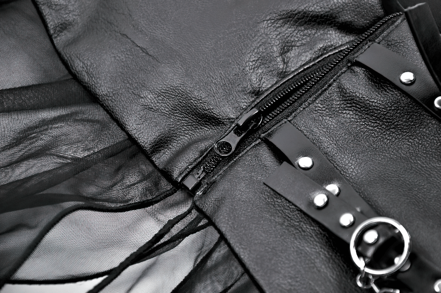 Close-up of women's black sheer maxi skirt showcasing lace-up waist, stud details, and zipper closure for an edgy look.