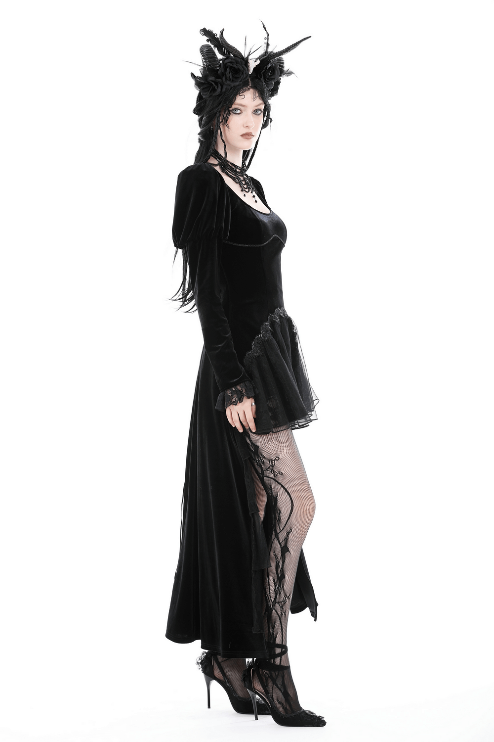 Elegant woman in black velvet gothic dress with lace hem and dramatic neckline, showcasing dark elegance and style.