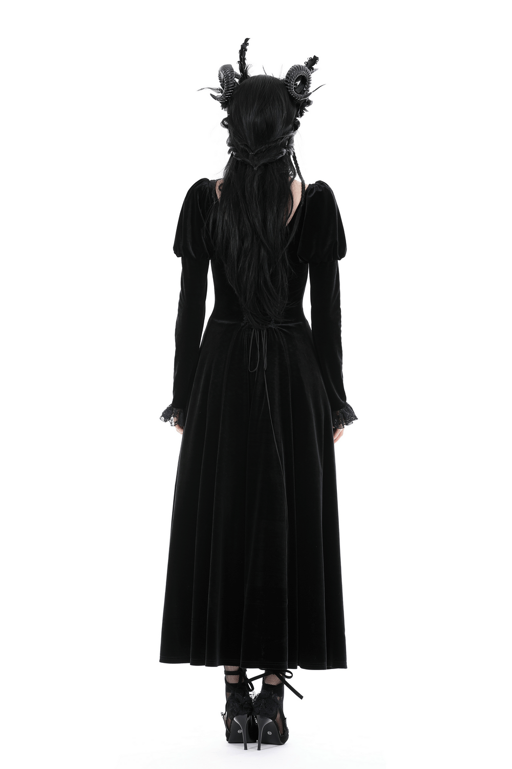 Back view of a woman in a black velvet Gothic high-low dress with ruffled neckline and lace hem, showcasing dramatic elegance.