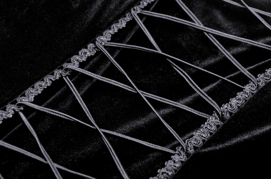 Close-up of luxurious black velvet fabric with intricate lace detailing and ruffle edges for gothic elegance.
