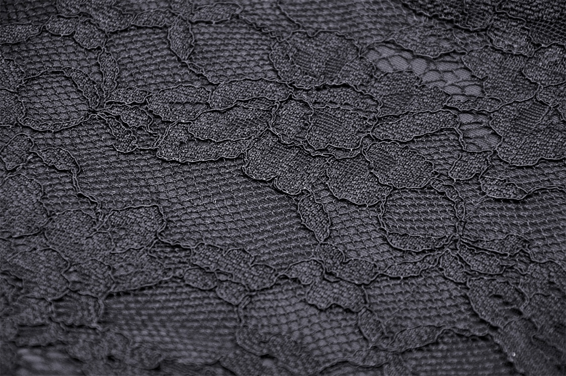 Close-up of intricate black lace fabric featuring floral patterns, perfect for gothic or elegant designs.